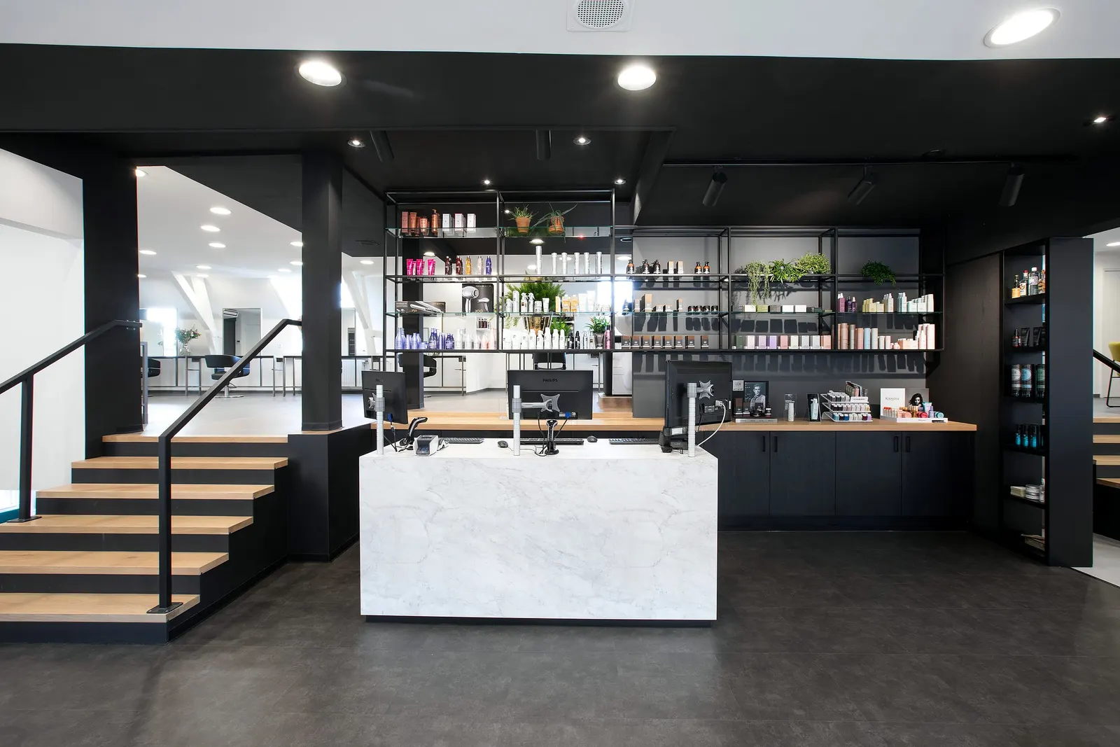 Interieur van kapsalon Jon Karelse met balie en stalen trap