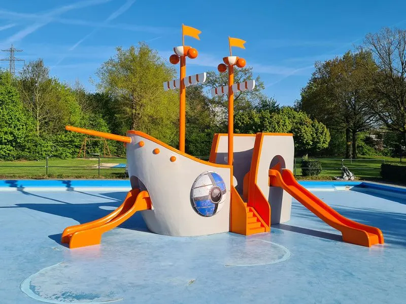 Speelschip met glijbanen in een buitenbad