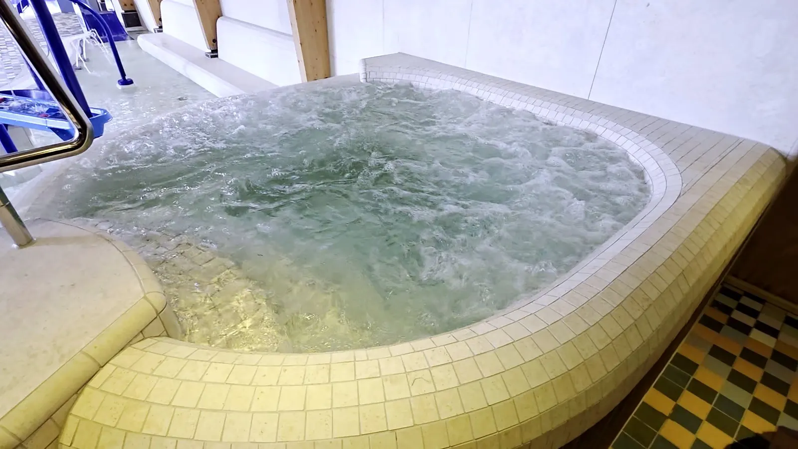 Bruisende betegelde whirlpool bij de overdekte waterspeeltuin van Paardekreek